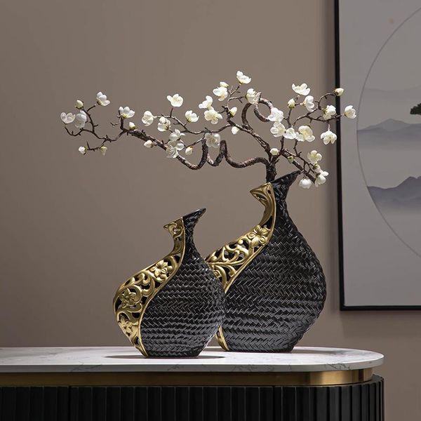Black and gold-plated hollow vase for abstract floral arrangements, a decorative ceramic handicraft perfect for living room or office decor